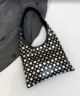 Bolso tipo tote de cuero sintético color borgoña, con apliques metálicos plateados y asa corta.