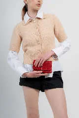 Billetera tipo sobre de cuero negro con cierre de elástico, separaciones internas y bolsillo con cierre para monedas.