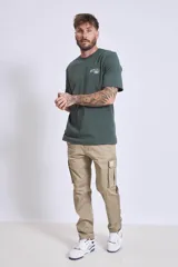 Remera de manga corta color marrón oscuro con cuello redondo y un pequeño texto bordado en blanco en el pecho.