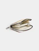 Billetera de cuerina color blanco con estampado de flores en tonos lila, naranja y amarillo. Tiene cierre superior, compartimentos para tarjetas y billetes, y un bolsillo interno con cierre.