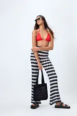 Pantalón tejido con motivo zigzag en tonos beige y blanco, de corte flare y cintura elastizada.
