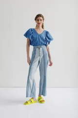 Blusa azul de escote pico y manga corta con volados en la parte delantera.