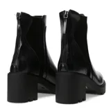 Bota de cuero negro con taco alto y suela gruesa, diseño moderno y sofisticado.