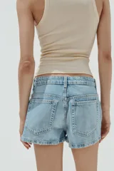 Shorts blancos de tiro medio con trabillas, bolsillos laterales y traseros. Cierre frontal con cremallera y botón metálico.