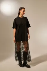 Vestido largo negro de algodón, corte holgado, con cuello redondo y sobrefalda de encaje negro transparente.