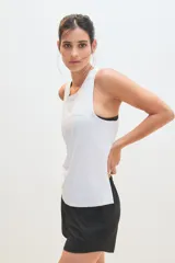 Musculosa deportiva blanca con logo pequeño en el pecho.