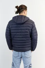 Campera puffer de nylon color azul marino, liviana y con capucha desmontable. Presenta cierre frontal y logo bordado en el pecho.