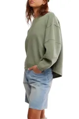 Camiseta de manga larga color verde oliva, con textura acanalada y silueta holgada extragrande. Presenta escote redondo, hombros caídos y puños anchos.