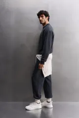 Sudadera de entrenamiento color gris claro, de corte relaxed fit, confeccionada en tejido de algodón con interior de rizo. Tiene cuello redondo, manga larga y acabados en rib.