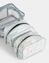 Neceser transparente con estampado floral, con manija superior y doble cierre.