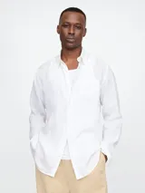 Camisa de lino blanca de manga larga con cuello clásico y bolsillo en el pecho.