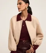 Campera bomber color beige con cuello y puños en color borgoña. Cierre frontal con cremallera y bolsillos laterales.