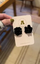 Aros tipo botón con forma de flor color rojo.