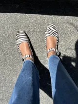 Zapatos tipo Mary Jane con estampado de cebra en pelo sintético, con correa sobre el empeine y hebilla metálica.