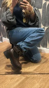 Botas de cuero color marrón oscuro, estilo Chelsea, con elástico lateral negro y suela track negra. Incluye correa de cuero desmontable con hebilla.