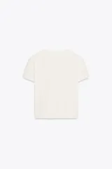 Camiseta color crema de algodón con efecto lavado, corte regular, cuello redondo, manga corta y texto marrón estampado en el frente con la frase 'Sun-Kissed in Maldives'.