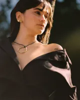 Collar con dije circular irregular de alpaca y plata 925, con hilo de algodón natural.