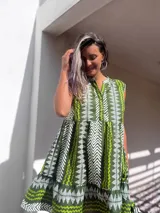 Vestido corto verde con estampado de líneas blancas, cuello en V y botones.