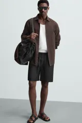 Bermuda negra de lino con calce relajado. Presenta cintura elástica ajustable con cordón, bolsillos frontales y un bolsillo trasero de plastrón.