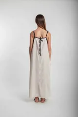 Vestido largo verde oliva de lino, con breteles finos negros y escote cuadrado con ribete negro.