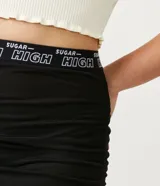 Pollera midi negra de tul con cintura elástica con la inscripción "Sugar High" y ajuste frontal con cordones.