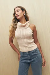 Top tejido de punto color beige, con cuello alto y diseño sin mangas.