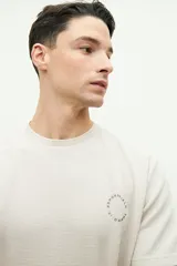 Remera color beige con textura, de manga corta, corte regular y logo estampado en el pecho.