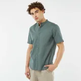 Camisa verde de manga corta con cuello mao y cierre frontal con botones.
