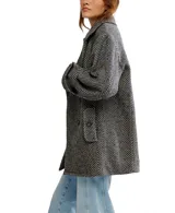 Abrigo tipo peacoat de corte oversize y silueta cuadrada, confeccionado en mezcla de lana con patrón de espiga en tonos negro y gris. Presenta cuello de solapa, cierre frontal de doble botonadura y mangas largas.