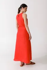 Vestido largo color rojo, sin mangas, con cuello redondo y lazo a la cintura.