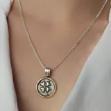 Gargantilla de plata 925 con dije circular con borde dorado y trébol plateado en el centro.