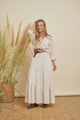 Pollera larga color beige, de corte holgado con volados en la parte inferior.