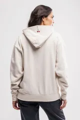 Canguro de felpa color crema, de corte oversize, con capucha y bolsillo tipo canguro. Tiene un pequeño bordado de cerezas en el pecho.