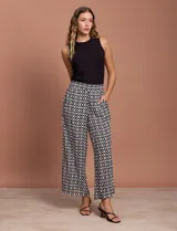 Pantalón capri estampado con flores en tonos celeste, blanco y negro. Tiene pretina elastizada en la parte trasera y bolsillos delanteros.