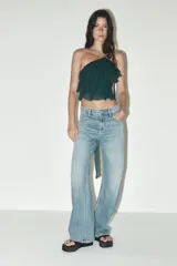 Pantalón de jean azul oscuro, de corte wide leg y tiro medio, con cinco bolsillos y cierre frontal con cremallera y botón metálico.