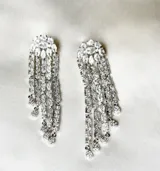 Aros largos plateados con forma de lágrima, con incrustaciones de zirconia y diseño de flecos.