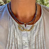 Collar de acero dorado con cadena larga, cierre rectangular y dije en forma de flor, desmontable.