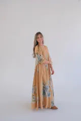 Vestido largo color camel con estampado de flores azules, corte amplio, escote en V y mangas 3/4.