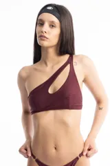 Top de bikini color borgoña, de un solo hombro con corte irregular y abertura en el frente.