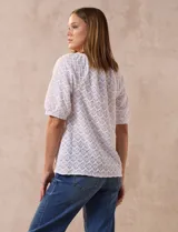 Blusa blanca labrada con cuello a la base, abertura central con botones y mangas cortas. Marca Sabrina Lauren.