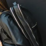 Mochila negra de cuero vacuno con tres compartimentos, uno de ellos acolchado para laptop.