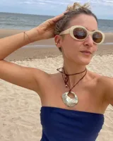 Collar con dije dorado en forma de concha marina y cordón marrón de seda natural.