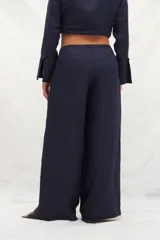 Pantalón de lino de tiro alto, con corte amplio a la cintura, confeccionado en dos colores: azul marino y marrón. Presenta un recorte delantero que estiliza la silueta. De calce cómodo.