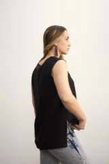 Blusa color crema sin mangas, de lino, con cuello redondo y corte recto.