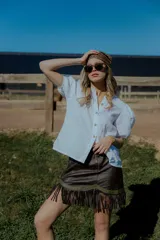 Camisa color ladrillo confeccionada en lino, con cuello mao, mangas cortas abullonadas y cierre frontal con botones.