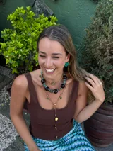 Collar corto con cuentas de madera color marrón oscuro, cuentas tibetanas con incrustaciones de color turquesa y detalles en metal color bronce. Cierre con cadena de acero quirúrgico y gancho para regular el largo.