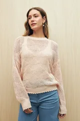Sweater calado color blanco de punto liviano con diseño geométrico, silueta relajada y terminación en rib en cuello, puños y ruedo.