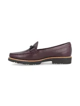 Mocasín de cuero negro con detalle de hebilla metálica plateada.