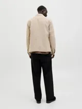 Blazer color beige de lino y algodón, corte slim fit, con solapa clásica, cierre con botón, bolsillo en el pecho y tejido plano resistente.