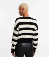 Cardigan corto con cuello en V, manga larga y cierre abotonado. Diseño a rayas horizontales en blanco y negro, confeccionado en tejido de punto con textura de pelo.